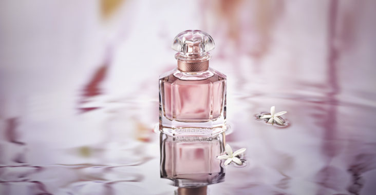 Une Bouteille De Parfum Chic à Côté D'une Voiture Rose.