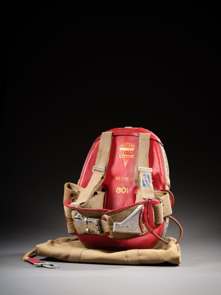 Le parachute Aviorex de Jean Mermoz, datant de 1935, avec son dos en cuir rouge marqué à l’or « L’Aviorex Mermoz 801 ».